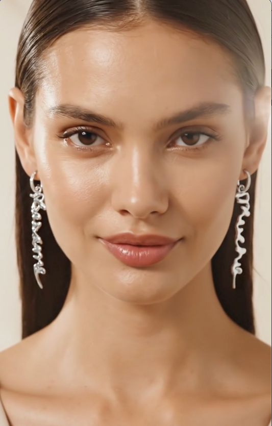 Silver Besame Mucho earrings on a model, close-up showing script lettering detail — Nounou Studio