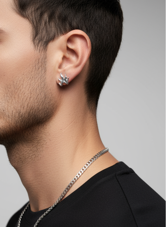 Close-up of a person wearing a silver  flame earring and necklace against a gray background