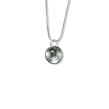 Silver necklace with a unique pendant  with a sapphire on a white background