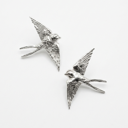 Sterling silver swallow stud earrings on white background — Nounou Studio