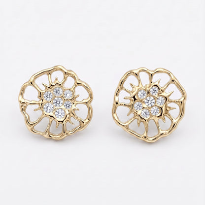 A pair of gold-toned flower-shaped stud earrings inspired by the floral motifs in lace, with clear gemstone centers, displayed on a clean light gray background.