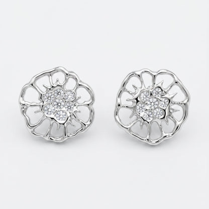 A pair of silver-toned flower-shaped stud earrings inspired by the floral motifs in lace, with clear gemstone centers, displayed on a clean light gray background.