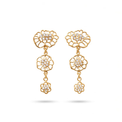 A pair of gold-toned dangle earrings with moissanites at the center, featuring three distinct floral designs inspired by lace motifs, connected by small chains, shown against a plain light gray background. 