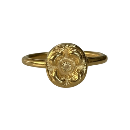 Gold lotte ring with intricate design on a white background