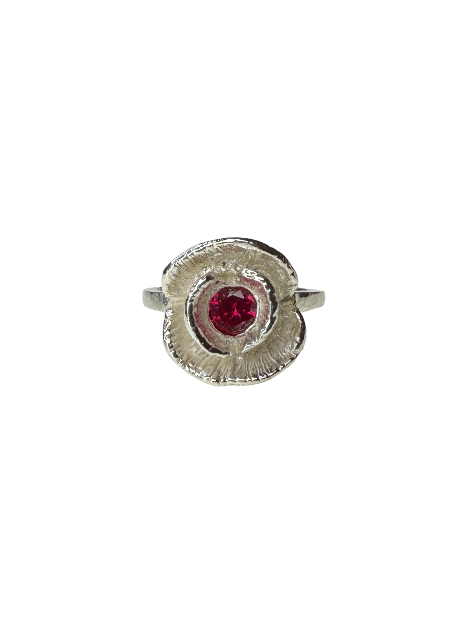 Silver ring with a red ruby on a white background