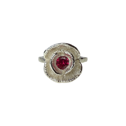 Silver ring with a red ruby on a white background