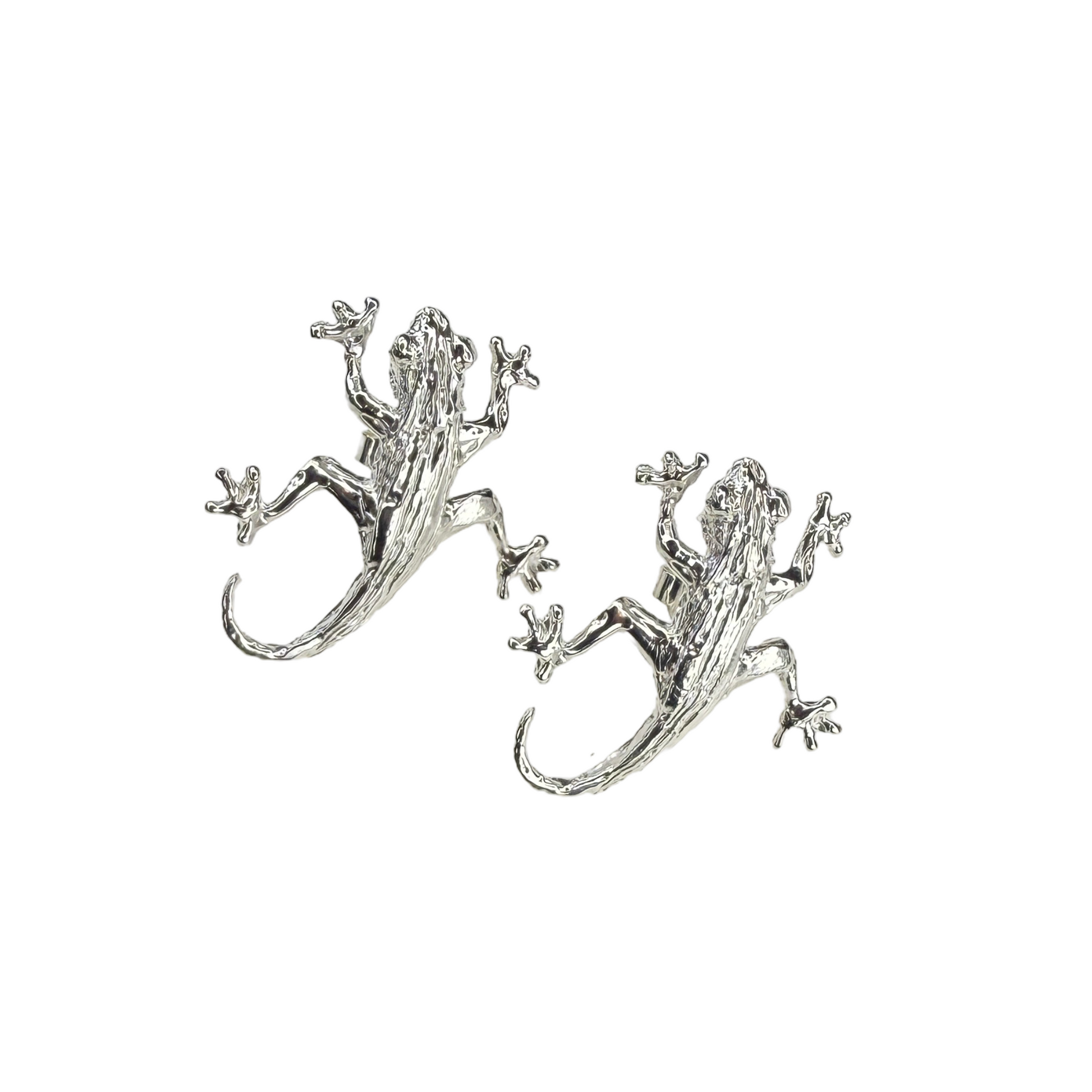 Silver lizard/gecko-shaped earrings on a white background