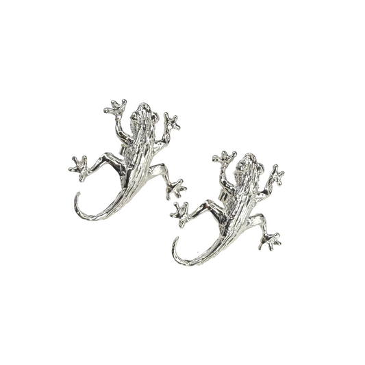 Silver lizard/gecko-shaped earrings on a white background
