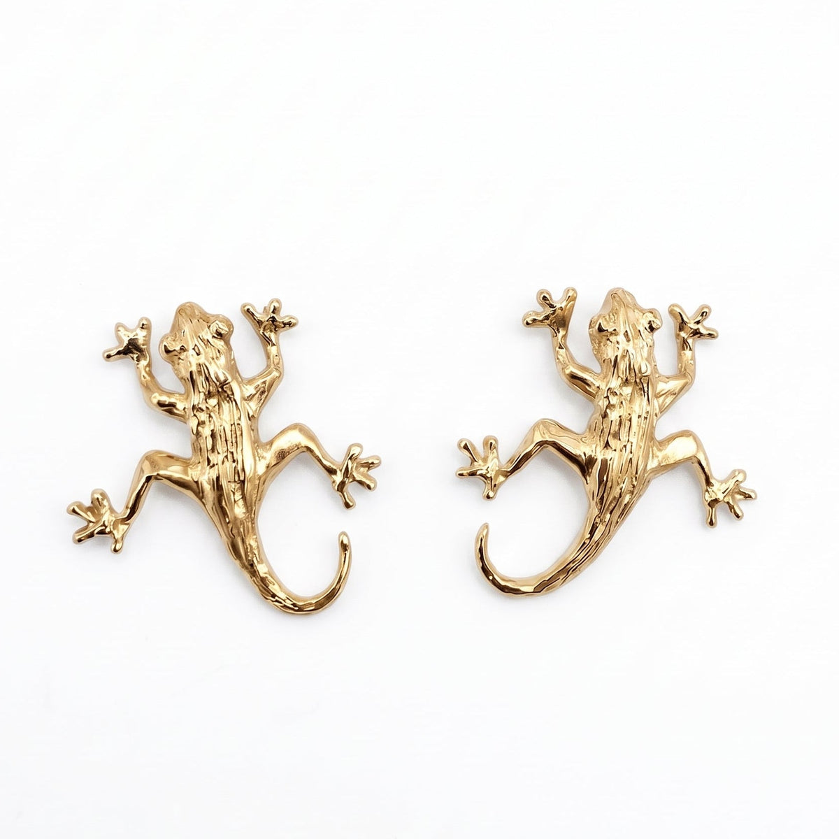 A pair of gold vermeil lizard stud earrings on a plain white background. From a jewellery store in Amsterdam.