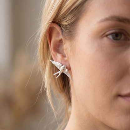 Handcrafted swallow stud earrings worn by a model — Nounou Studio"