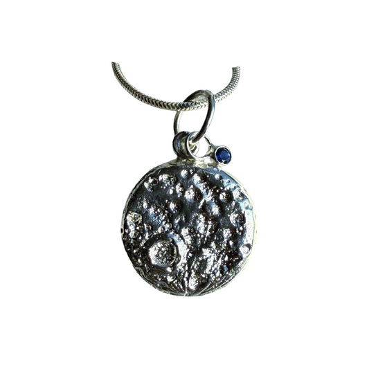 Silver and sapphire moon pendant necklace on a white background
