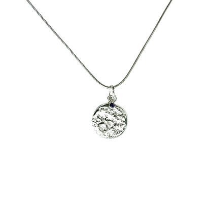Silver and sapphire necklace with a moon pendant on a white background