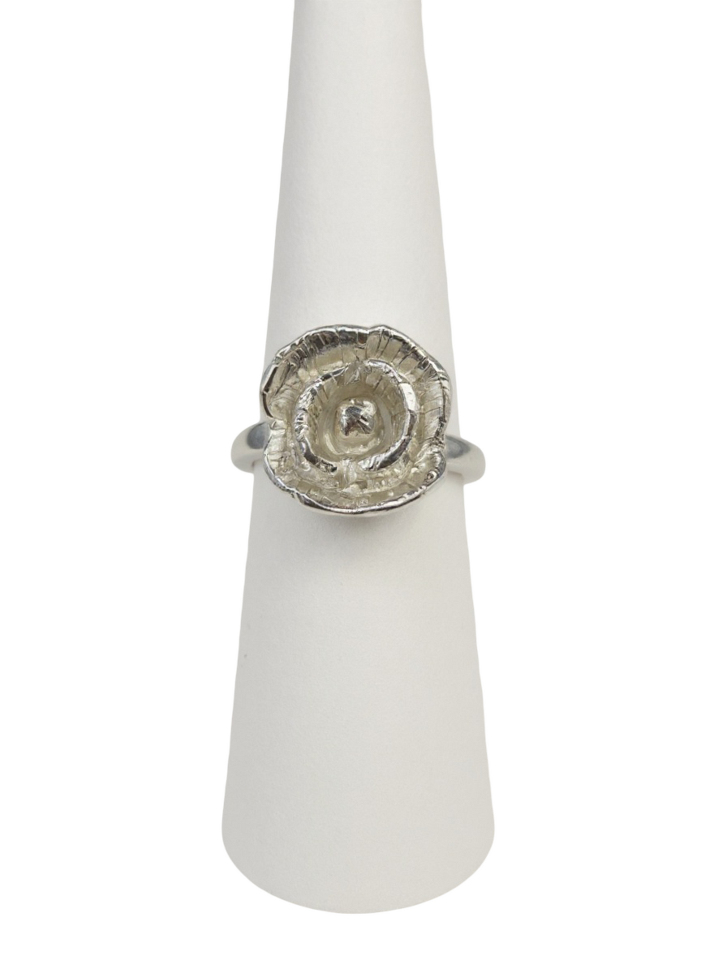 Silver ring with a textured poppy flower design on a white stand