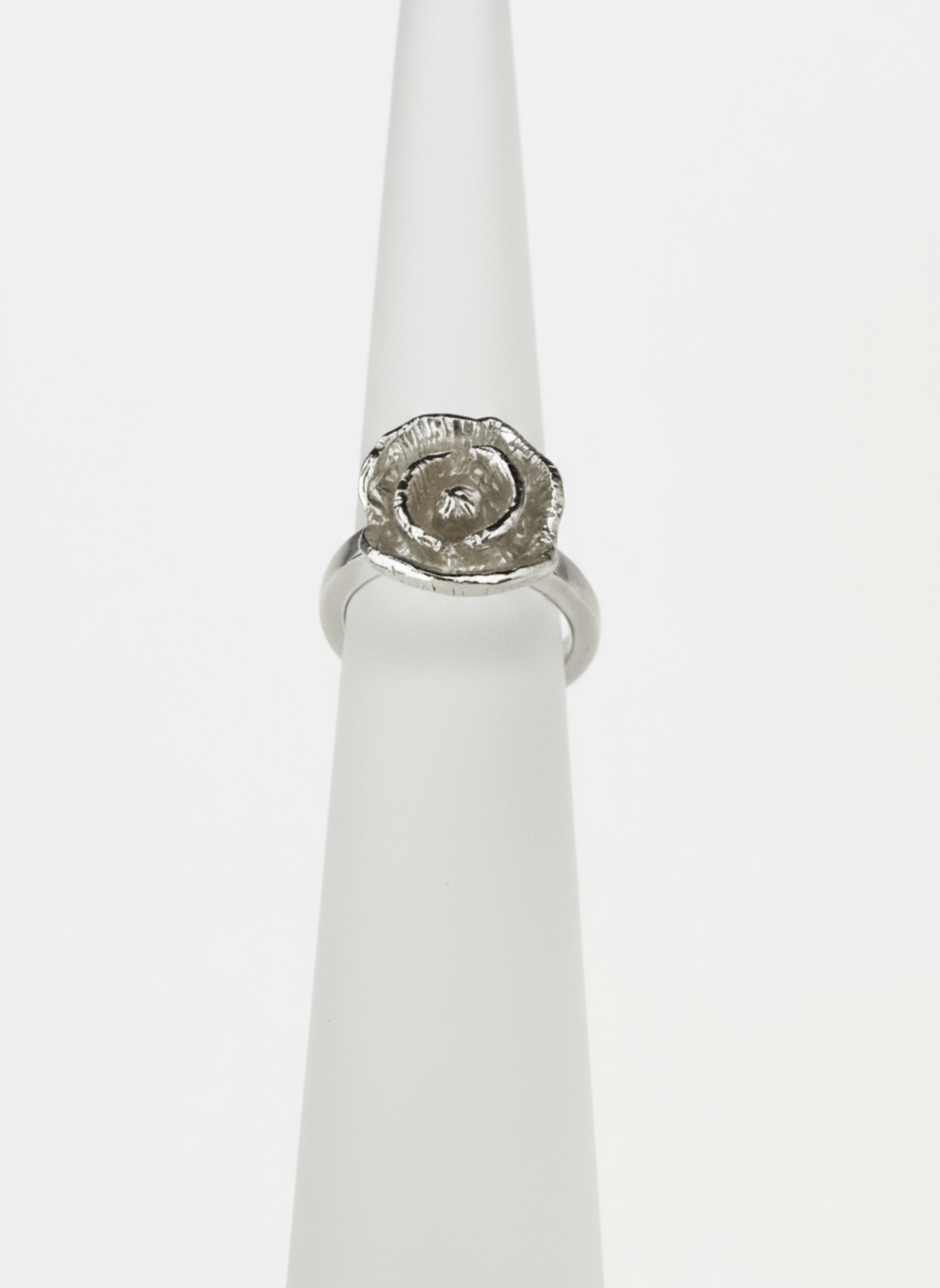 Silver ring with a poppy design on a white background