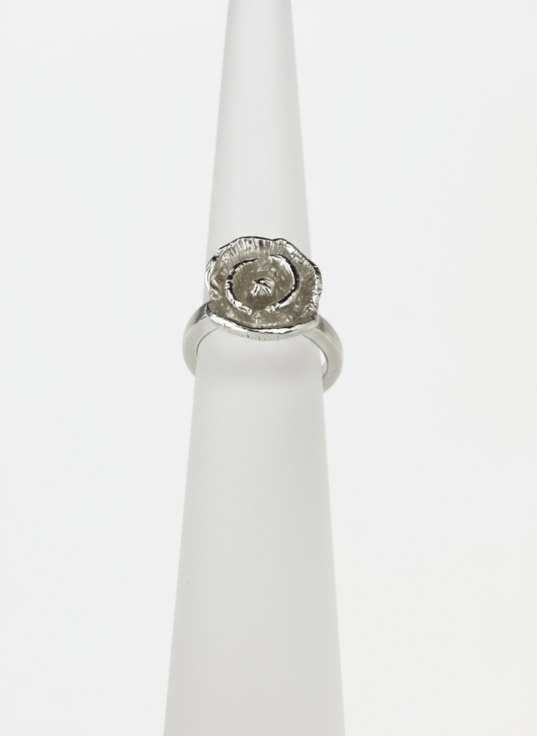 Silver ring with a poppy design on a white background